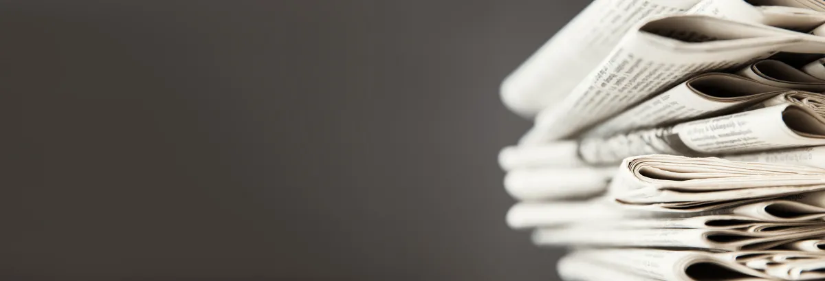 stack of newspapers on a dark grey background