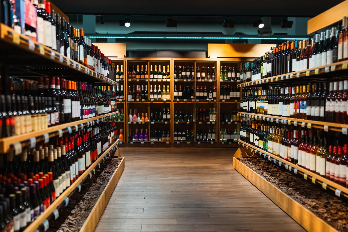 a retail store aisle with shelves lined with liquor bottles