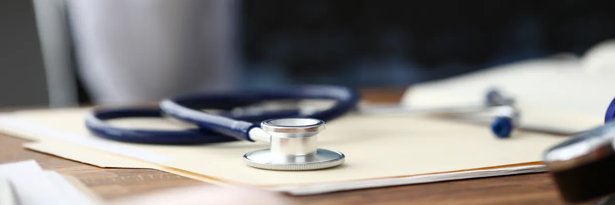 stethoscope lying on a table on top of a file folder